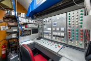 Místní kruhový urychlovač elektronů Mikrotron MT25 vyžaduje dostatečně výkonný napájecí zdroj a zároveň při plném výkonu potřebuje 2,5 metru betonového stínění. Obě podmínky splňuje prostor pod vrchem Vítkov v pražském Karlíně.